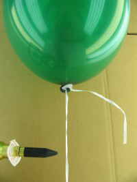 Luftballon mit Helium, der mit einem Fixverschluss mit Ballonband verschlossen ist