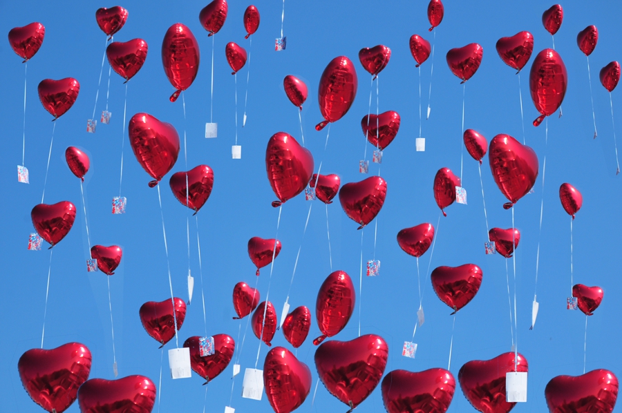 Herzluftballons aus Folie steigen mit Ballonflugkarten zur Hochzeit auf